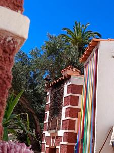 a building with a colorful fence with a palm tree in the background at Santa Lucía AgroRural in Santa Lucía