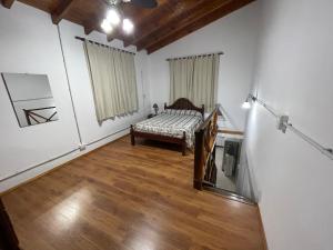 een kamer met een bed en een spiegel bij Asharam Asociación Argentina de Yoga in Mina Clavero