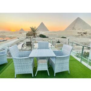 a table and chairs with a view of the pyramids at White House Pyramids View in Cairo