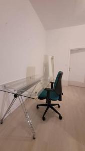 a glass desk and a green chair in an empty room at Schöne Apartment im Zentrum Gelsenkirchen in Gelsenkirchen