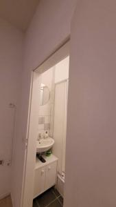 a white bathroom with a sink and a mirror at Schöne Apartment im Zentrum Gelsenkirchen in Gelsenkirchen