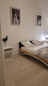 a bedroom with a bed and a table and two pictures at Schöne Apartment im Zentrum Gelsenkirchen in Gelsenkirchen