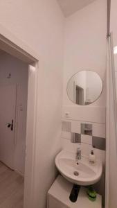 a white bathroom with a sink and a mirror at Schöne Apartment im Zentrum Gelsenkirchen in Gelsenkirchen