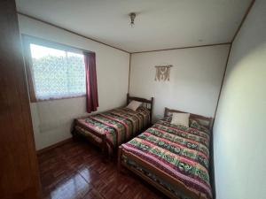 1 Schlafzimmer mit 2 Betten und einem Fenster in der Unterkunft cabaña Wenu Mapu queule in Queule