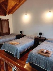 Habitación con 2 camas individuales y 2 mesas. en Terrazas Ushuaia en Ushuaia