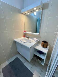 y baño con lavabo y espejo. en LA PLAYA - L'Appartement COZY - 2 à 5 personnes, en Sainte-Anne