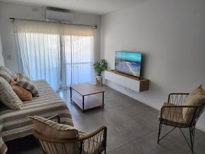 a living room with a couch and chairs and a flat screen tv at Miradores Sáenz Peña in Tigre