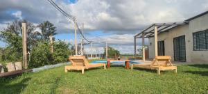 a yard with two chairs and a table and a pool at Quinta Loma Hermosa in Aldea Brasilera