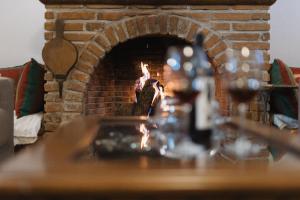 a brick fireplace with a table in front of it at TrikalaBnB - Billiard Home in Trikala in Tríkala