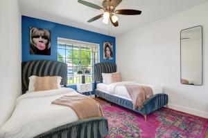 a bedroom with two beds and a ceiling fan at IndyOasis: pool*spa*games*BBQ*4BR2BA. Wlk2Festivls in Indio