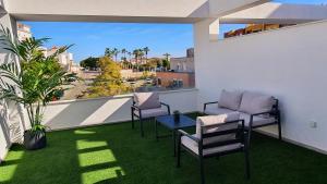 a balcony with chairs and a table and a view at BlueSkyEsteponaGardens in Estepona