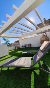a patio with a lounge chair on the grass at BlueSkyEsteponaGardens in Estepona