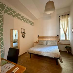 a bedroom with a bed and a table and a mirror at Le camere del Nonno Luigi in Naples