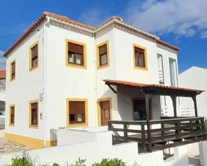 a white house with a brown roof at Na Rota - Casa de Praia in Zambujeira do Mar