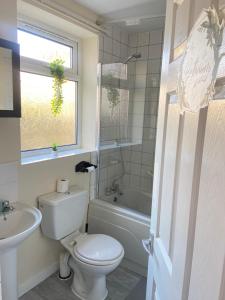 een witte badkamer met een toilet en een wastafel bij Kisobi Home Bedroom 2 in Hull