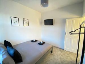 Un dormitorio con una cama y un televisor en la pared. en Kisobi Home Bedroom 2, en Hull