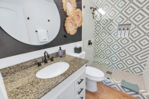 a bathroom with a sink and a mirror and a toilet at IndyOasis: pool*spa*games*BBQ*4BR2BA. Wlk2Festivls in Indio +63 photos