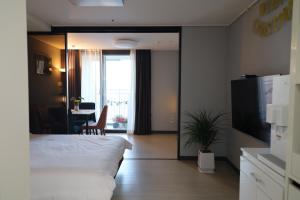 a bedroom with a bed and a table and a window at Sim On Chae - one room in Yeosu