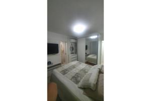 1 dormitorio con cama y espejo grande en Apartamento 2 dormitórios Luíz XV, en Balneário Camboriú