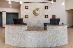 a reception desk with a c logo on the wall at Comfort Suites in Granbury