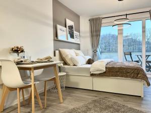 a bedroom with a bed and a desk and a table at Modernes Apartment inkl. TG-Stellplatz in der Nähe zum Bahnhof - YUKA Apartments in Schwäbisch Hall