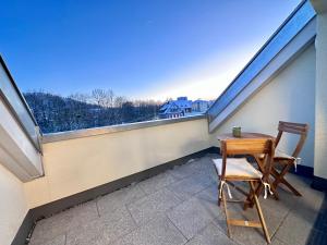 a table and a chair on a balcony with a view at Modernes Apartment inkl. TG-Stellplatz in der Nähe zum Bahnhof - YUKA Apartments in Schwäbisch Hall