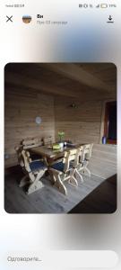 un tavolo e sedie in legno in una stanza di Fruskogorske brvnare a Velika Remeta