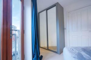 um quarto com um espelho e uma cama com uma janela em Broughton House with Free Parking, Balcony, Fast Wifi and Smart TV with Netflix by Yoko Property em Milton Keynes