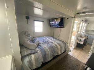 a small bedroom with a bed and a tv on the wall at Midtown Charm: 1BR Urban Pad in Reno