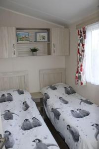 ein Schlafzimmer mit 2 Betten mit Vögeln auf der Bettwäsche in der Unterkunft Cosy beachfront getaway in Mersea in West Mersea