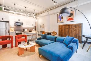 a living room with a blue couch and a kitchen at Luxury 1bd in Downtown LA in Los Angeles
