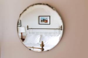 a mirror reflecting a bed with white pillows at s u n s e t s h a c k Binalong in Binalong Bay