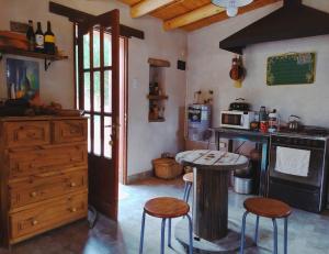 a kitchen with a table and two stools in it at La Casa de Tilcara in Tilcara