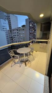 uma mesa e cadeiras na varanda de um edifício em Lindo Ap no melhor de Copacabana no Rio de Janeiro