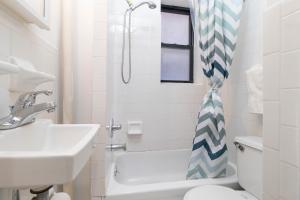 ein Bad mit einem Waschbecken, einem WC und einer Dusche in der Unterkunft The Upper East Side Monthly Rentals Apartments in New York