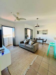 uma sala de estar com um sofá e uma mesa em Lindo Apartamento Vista mar Portaria 24h Piscina e Lazer no Guarujá