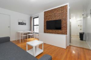 sala de estar con sofá y pared de ladrillo en The Upper East Side Monthly Rentals Apartments, en Nueva York