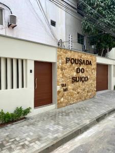 um edifício com duas portas de garagem e um sinal nele em Pousada do Suiço em Fortaleza
