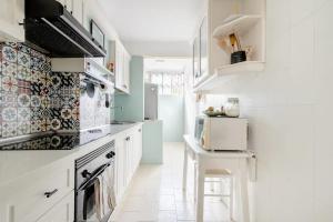 a kitchen with white cabinets and a white counter top at SantaRooms in Santa Cruz de Tenerife