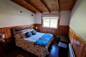 een slaapkamer met een bed en een raam bij Casa en Villa García, cerca de Melipeuco y Cunco in Cunco