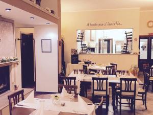 un restaurante con mesas y sillas blancas y un cartel en Villa della Mimosa, en Alia