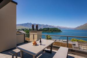 a balcony with a table and a view of the water at 3-bedroom Penthouse Apartment with Spa - The Beacon 1002 in Queenstown