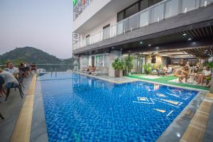 a large swimming pool on the side of a building at Cat Ba Paradise Hotel - Travel Agency in Cat Ba
