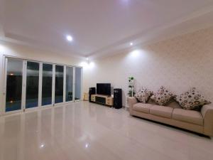 sala de estar con 2 sofás y TV en MG'S Villa en Batu