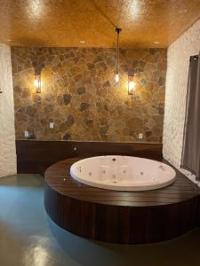 a bathroom with a large tub with lights on the wall at Kanto do Chico in Icaraí