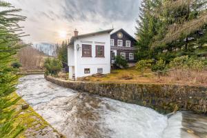 a house with a river in front of it at Pension Amálka in Rokytnice nad Jizerou