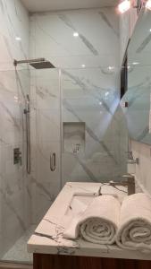 y baño con ducha y lavabo con toallas. en San pancho bungalows, en San Francisco