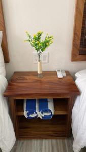 una mesa de madera con un jarrón con flores amarillas. en San pancho bungalows, en San Francisco