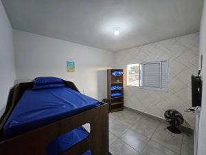 a small bedroom with a bed and a window at Apartamento 2 Quartos Bertioga WVM in Bertioga