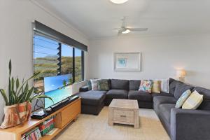 a living room with a couch and a large tv at Acutterbove in Point Lookout